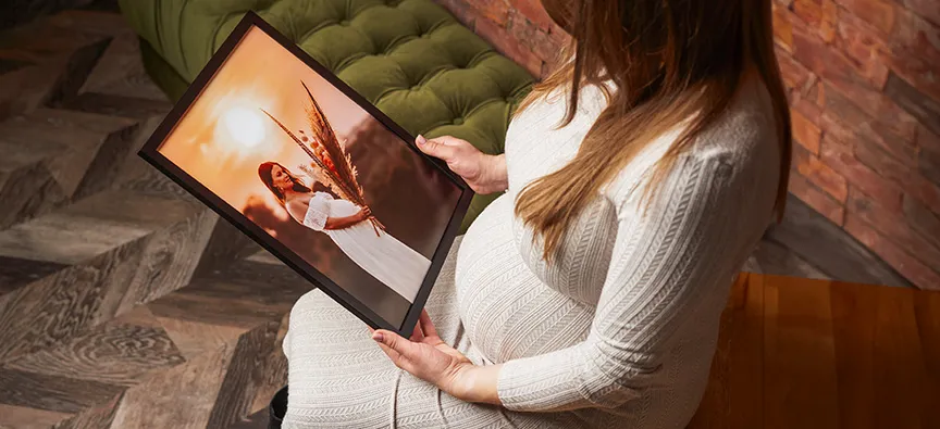 Zdjęcie z sesji ciążowej w plenerze na obrazie w ramie. 
